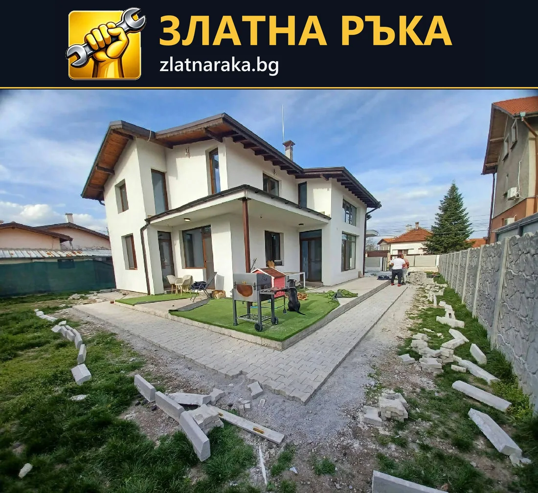 Двор около двуетажна къща с нови алеи от павета, тревни участъци и довършителни материали.