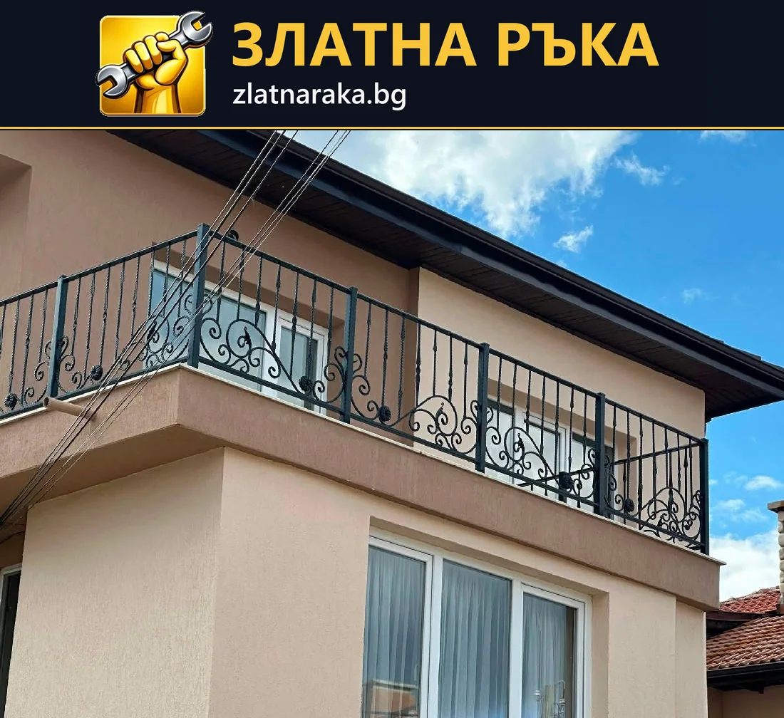 Черен метален парапет с извити орнаменти по дълъг балкон на светла двуетажна къща