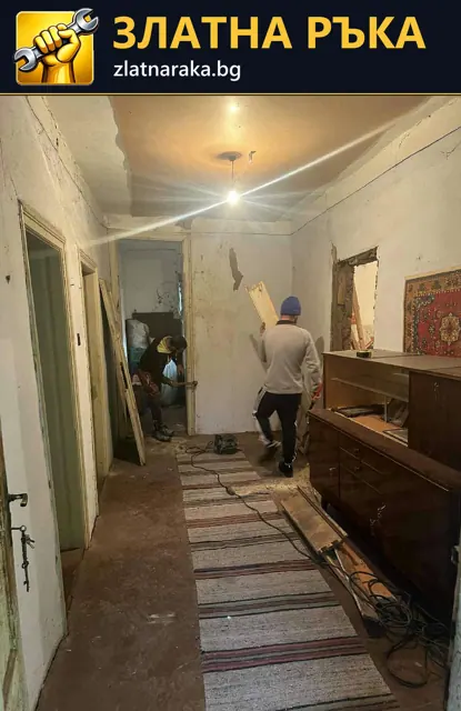 Боядисване и подготовка на стени в обитаван коридор с покрити вещи и майстор в работен процес.
