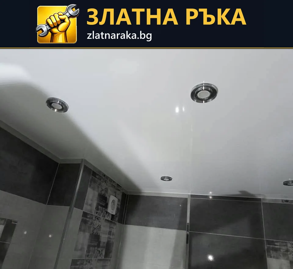 Гланцов бял таван с кръгли вградени светлини над сива облицовка в баня