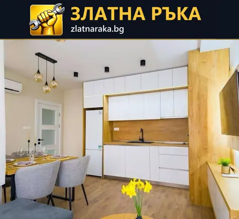 Бели кухненски шкафове с дървесна рамка и гръб са съчетани с малка маса и сиви тапицирани столове