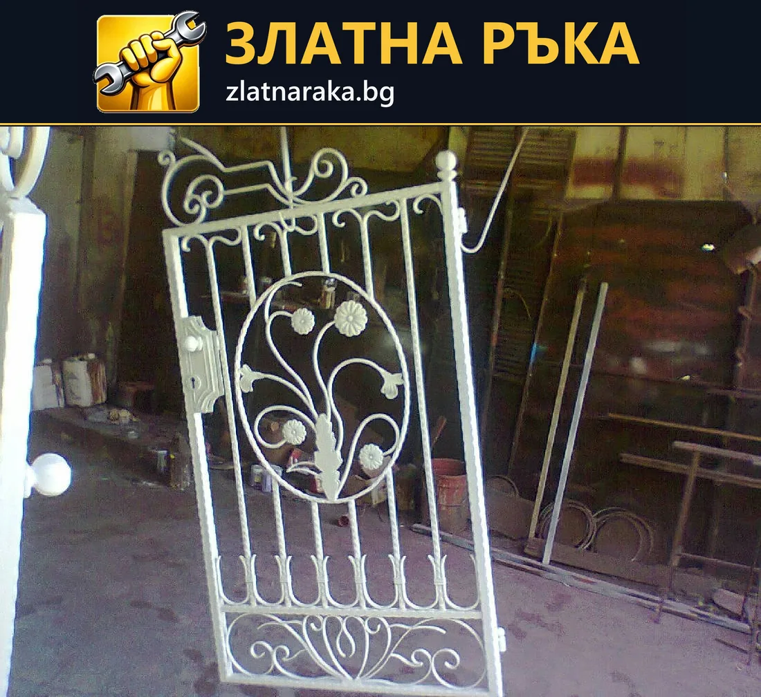 Бяло метално пано с вертикални пръти, извити орнаменти и листа в работилница.