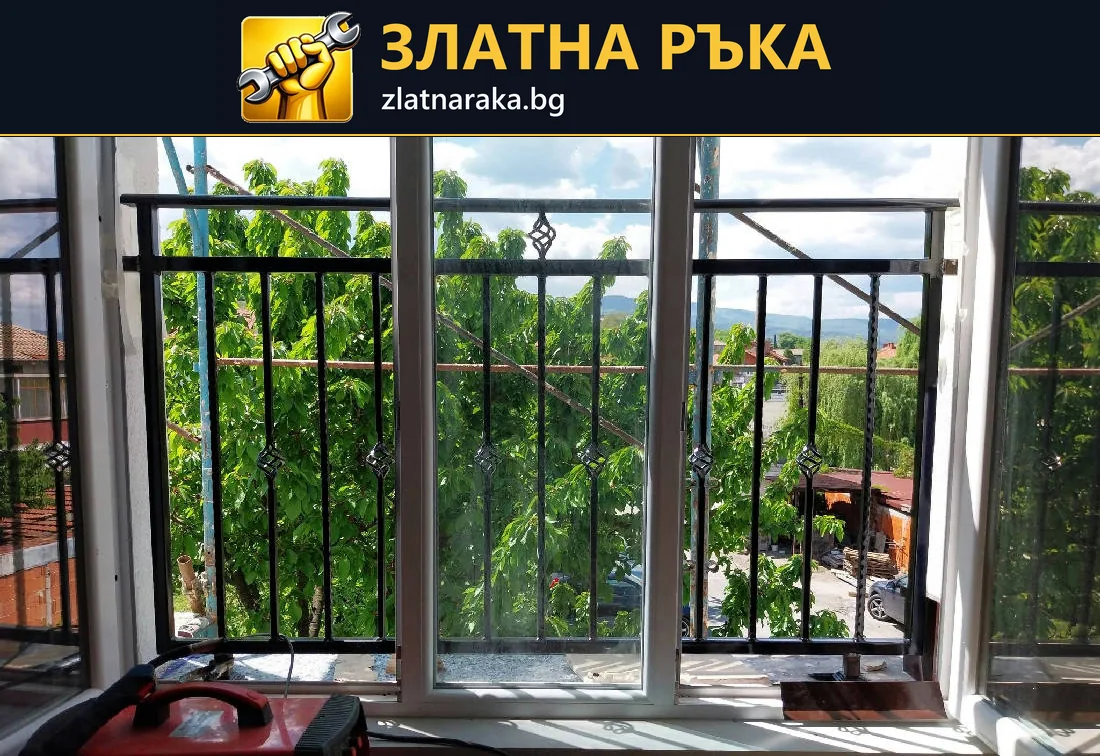 Метален парапет с вертикални пръти и малки ромбовидни акценти пред прозоречни отвори