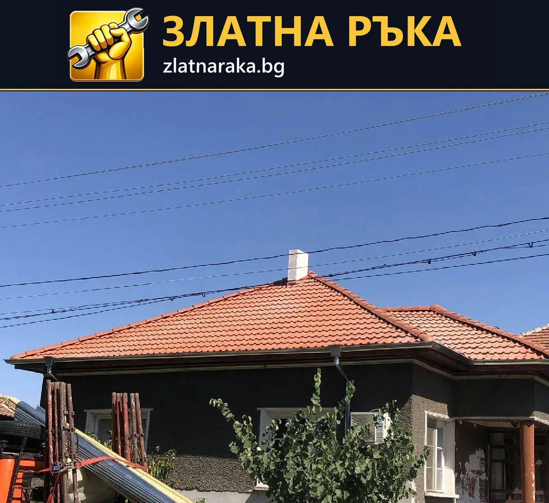 Къща с червен многоскатен керемиден покрив, широки стрехи и комин над тъмна фасадна повърхност