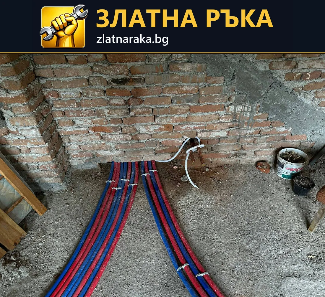 Група червени и сини защитени тръбни линии по пода, изведени към оголена тухлена стена.