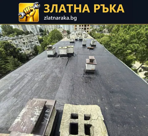 Тъмен плосък покрив на висока сграда е прекъснат от редица правоъгълни шахти и други покривни надстройки
