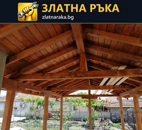 Поглед отдолу към дъсчен таван, напречни греди и дървени подпори на навес