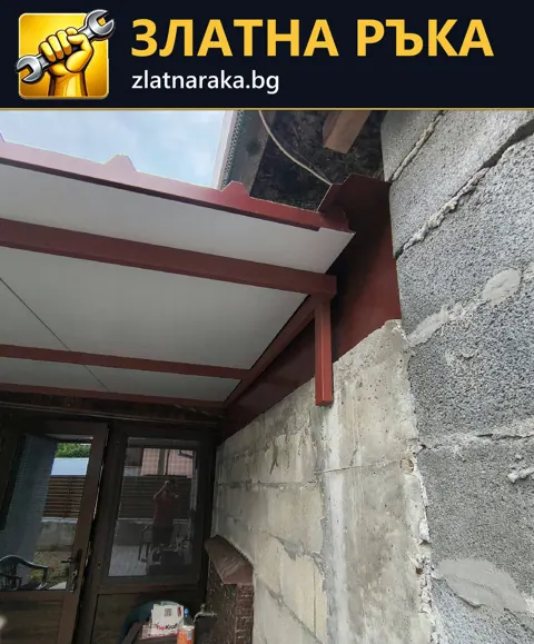 Червени метални носещи елементи и светли покривни панели до блокова стена