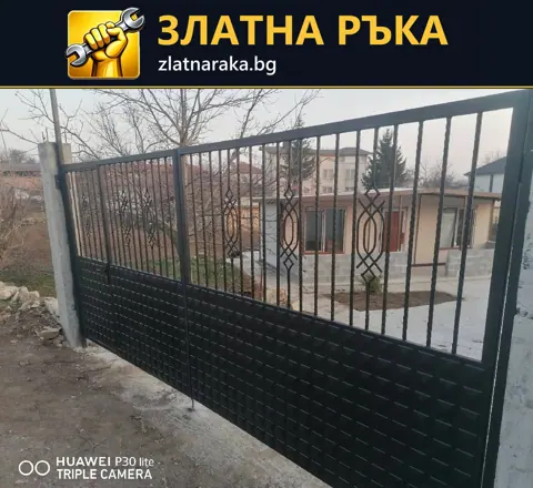 Тъмна метална порта с релефен плътен долен панел и вертикални пръти с декоративни орнаменти