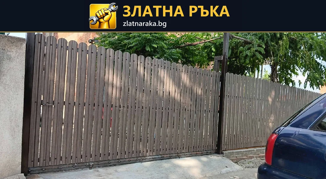 Широка дворна врата от вертикални ламели в дървесен цвят между бетонни оградни стълбове