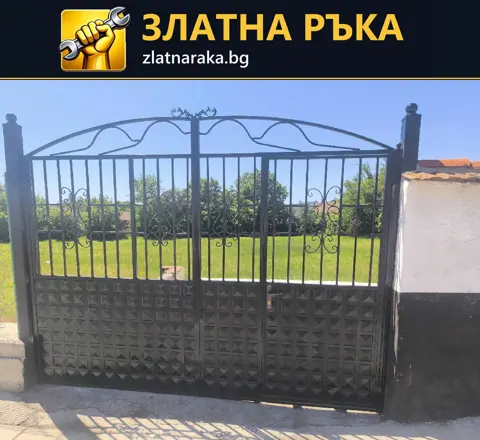 Двукрила метална дворна врата с извита горна рамка, декоративни елементи и плътна долна част.