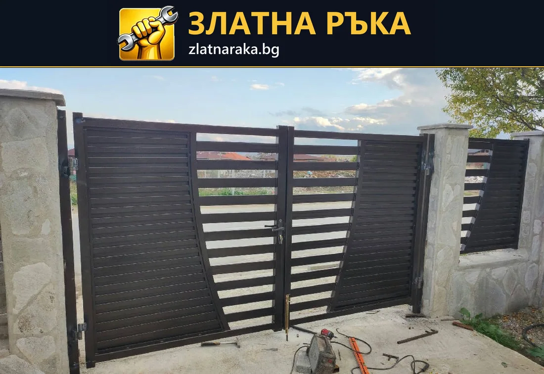 Тъмна двукрила порта между бетонни колони съчетава хоризонтални ламели и плътни странични полета
