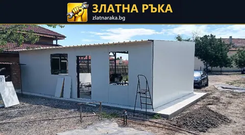 Малка едноетажна постройка със светли външни панели, отвор за врата и два прозоречни отвора