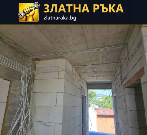 Множество светли електрически кабели следват тавана и се спускат по незавършени стени от блокчета