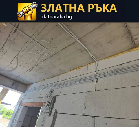 Кабели и гофрирани тръби върху бетонна плоча над зидана стена