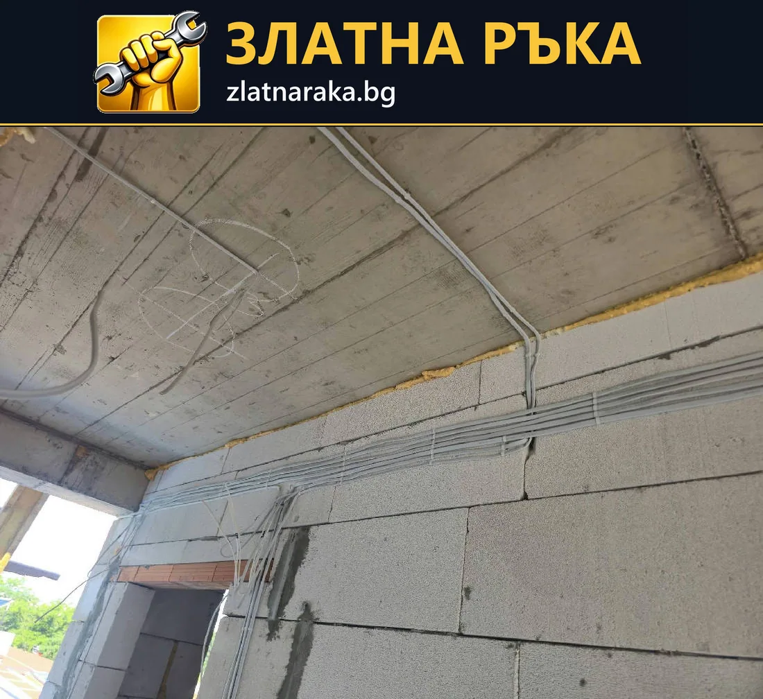 Кабели и гофрирани тръби върху бетонна плоча над зидана стена