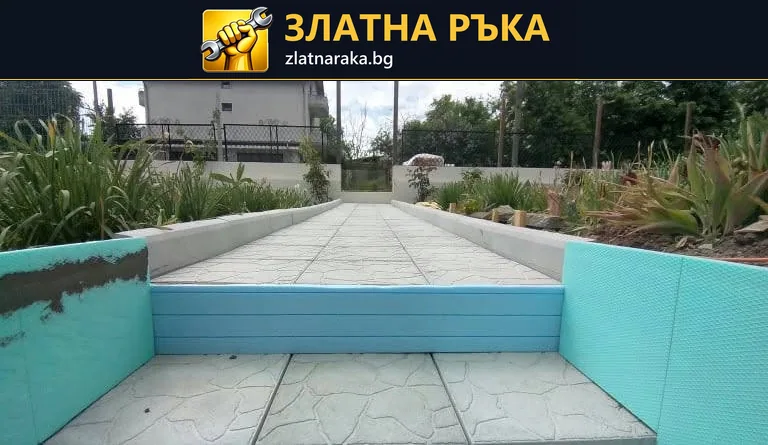 Светла павирана алея преминава през ниско синьо стъпало между тюркоазени бордове и озеленени участъци