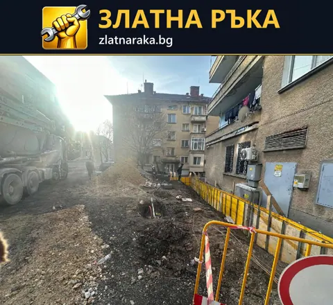 Разкопан участък край жилищна фасада с жълти кофражни пана, земна маса и строителна техника