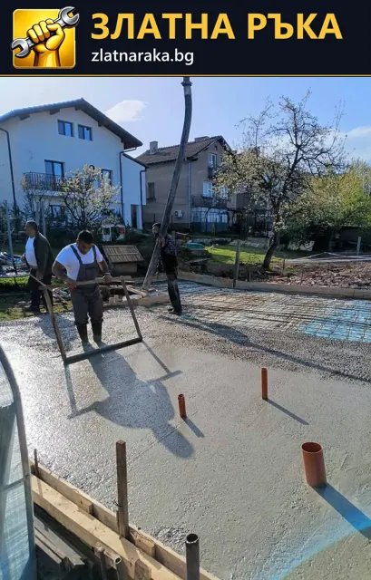 Работници изравняват пресен бетон в кофраж, с видими изведени тръби и материал около площадката.