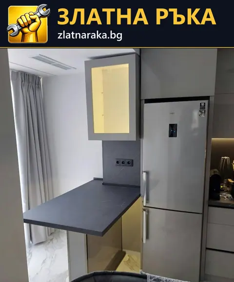 Светли кухненски шкафове с тъмен плот и жълта ниша над малка маса