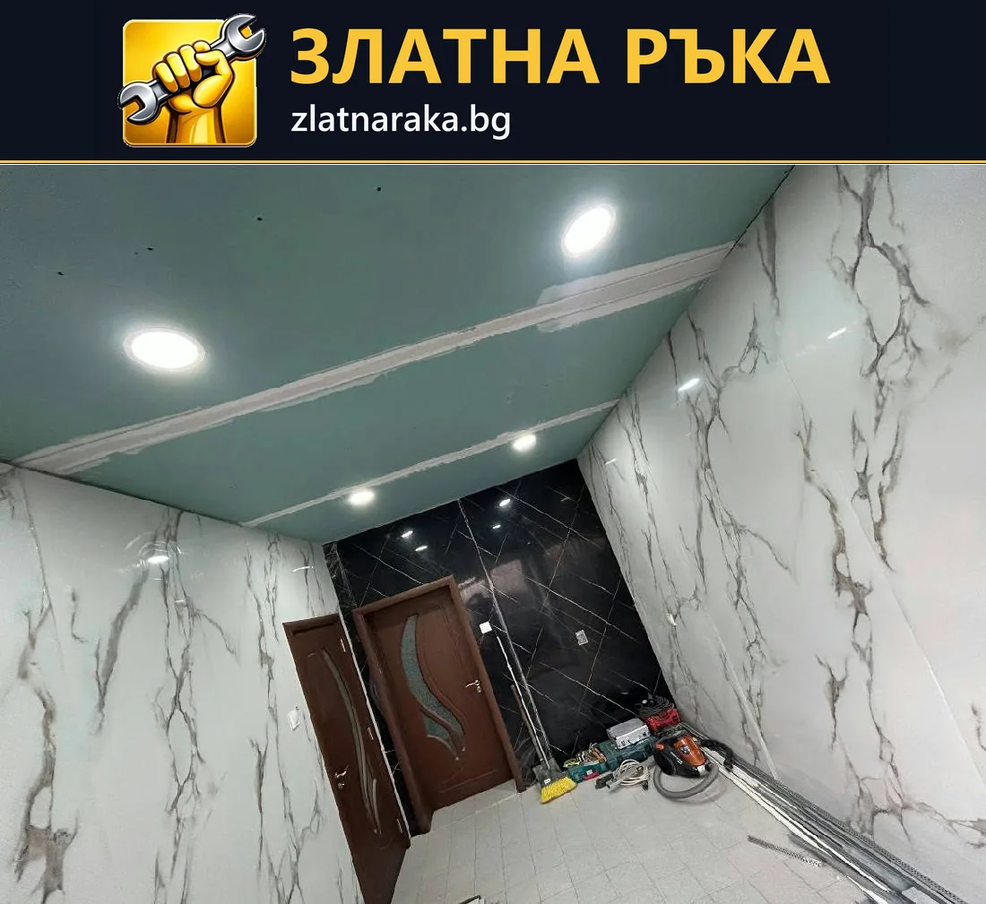 Тесен коридор със зелен таван, вградени светлини и светли стени с тъмен рисунък