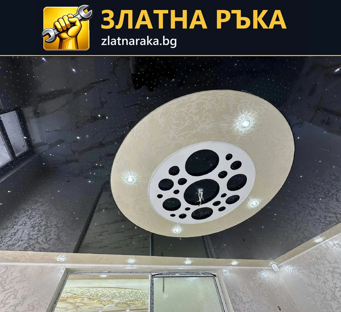 Светъл кръгъл елемент с вградени лампи върху лъскав тъмен таван над огледални врати