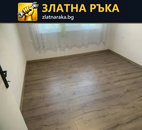Малка празна стая с ламиниран под в кафяво-сив дървесен декор и первази покрай стените