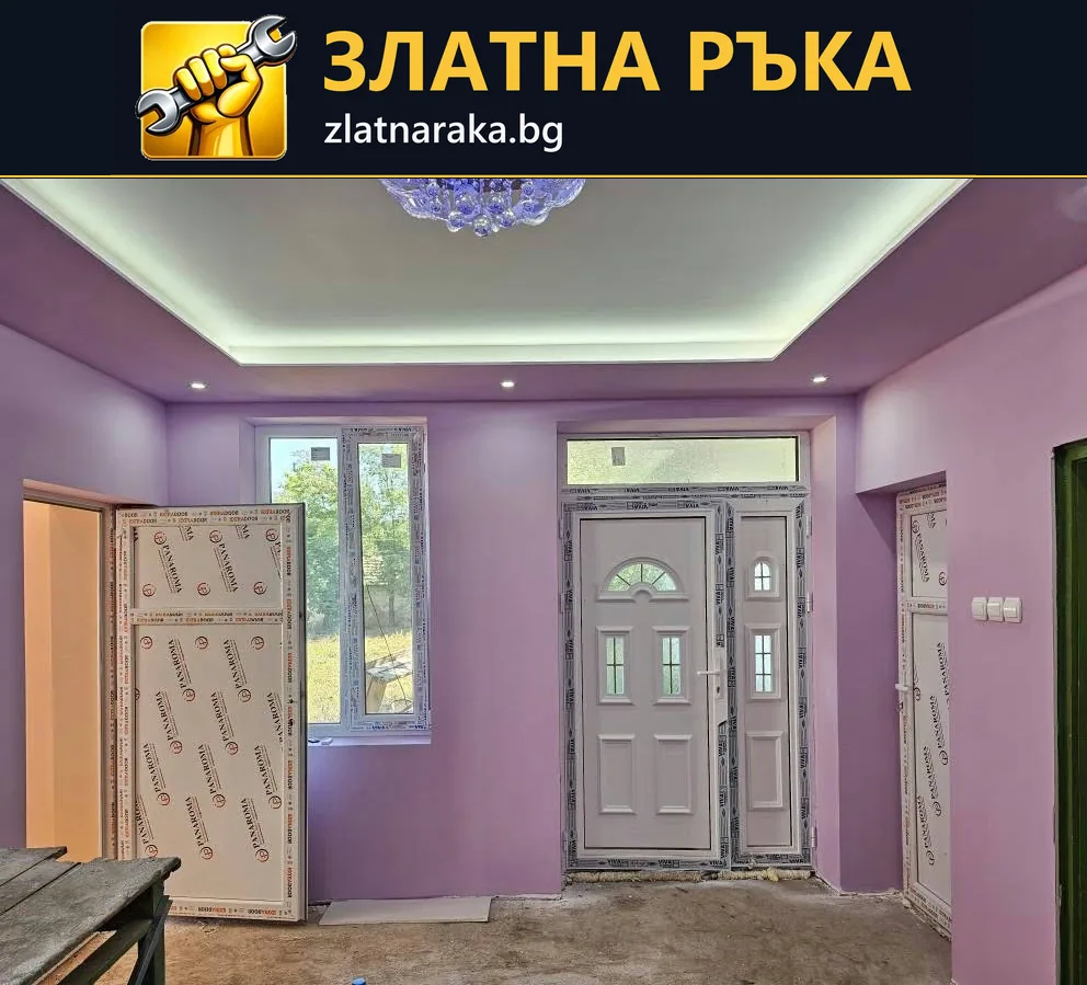 Стая с лилави стени, светла входна врата и окачен таван със скрито осветление и малки лунички