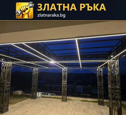 Покрита тераса с декоративни метални колони и ярки линейни лампи по покривната рамка.