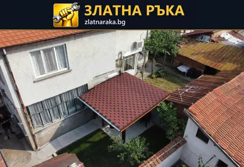 Малък червен навес до фасада на къща