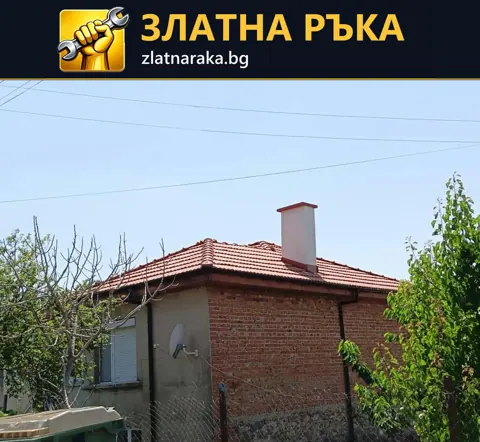 Едноетажна къща с червена тухлена фасада, светло измазан участък, керемиден покрив и висок светъл комин