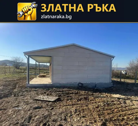 Едноетажна малка постройка със светли стенни плоскости, скатен покрив и отворена веранда.