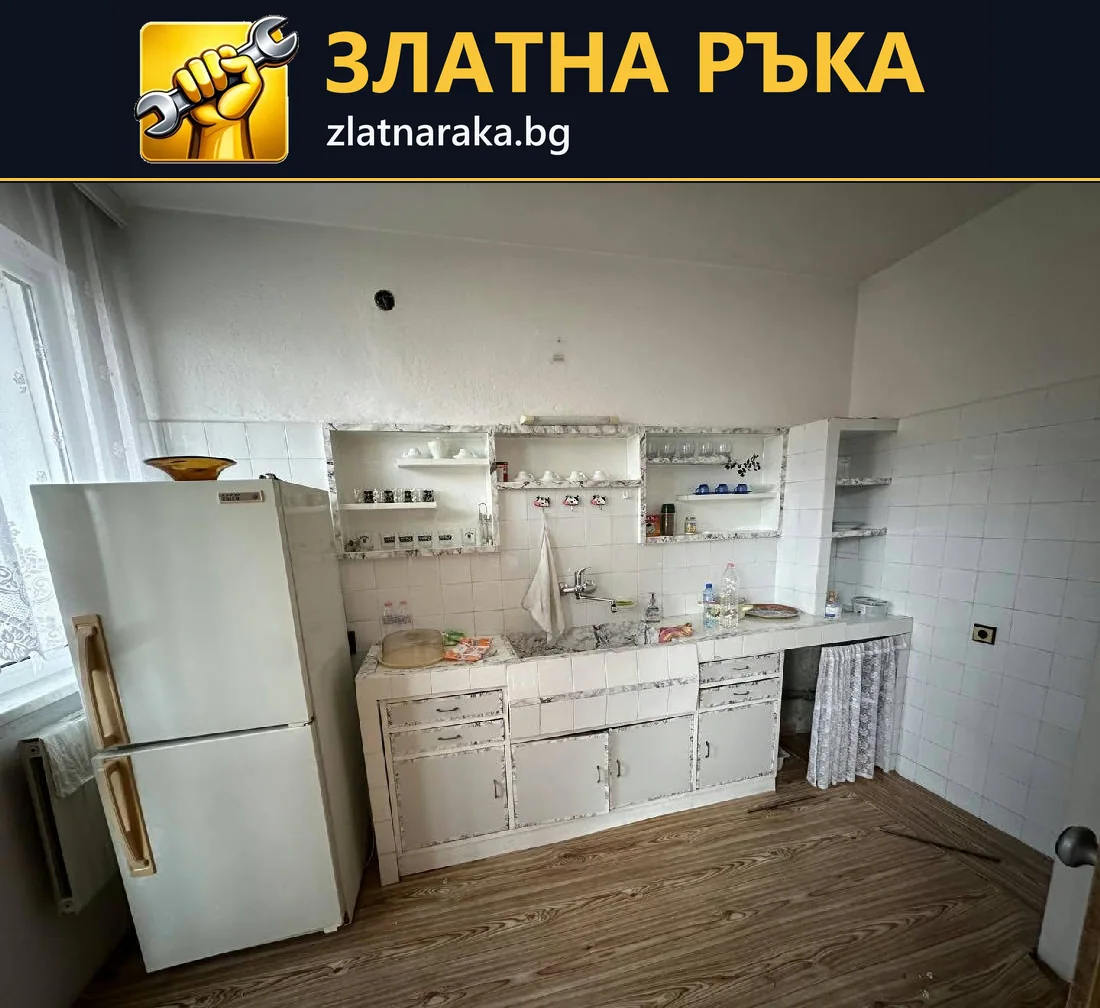 Бели кухненски шкафове с износени фронтове под открити стенни рафтове.