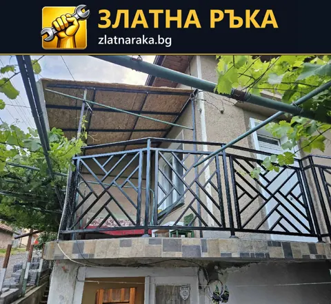 Тъмен метален парапет от правоъгълни пана с диагонални пръти на външна тераса.