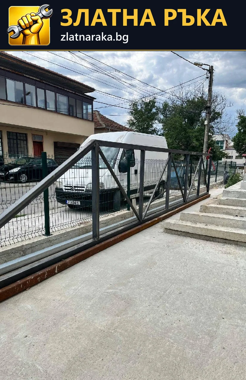 Тъмен метален парапет с диагонални връзки върви покрай рампа до външни стъпала