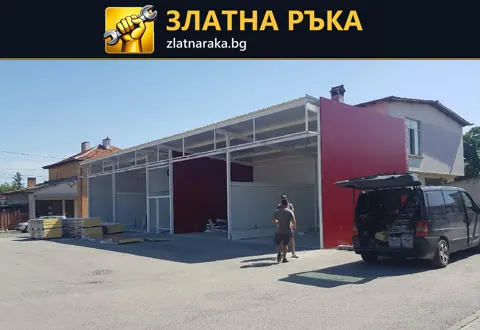 Дълга метална рамка с няколко отвора, частично поставени сиви панели и червена крайна стена.