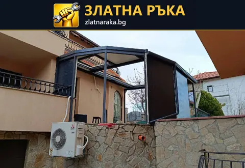 Тъмна метална рамка с покрив и частична облицовка над входна тераса