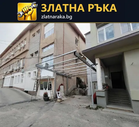 Правоъгълна сива метална рамка с успоредни напречни профили пред вход до външни стъпала
