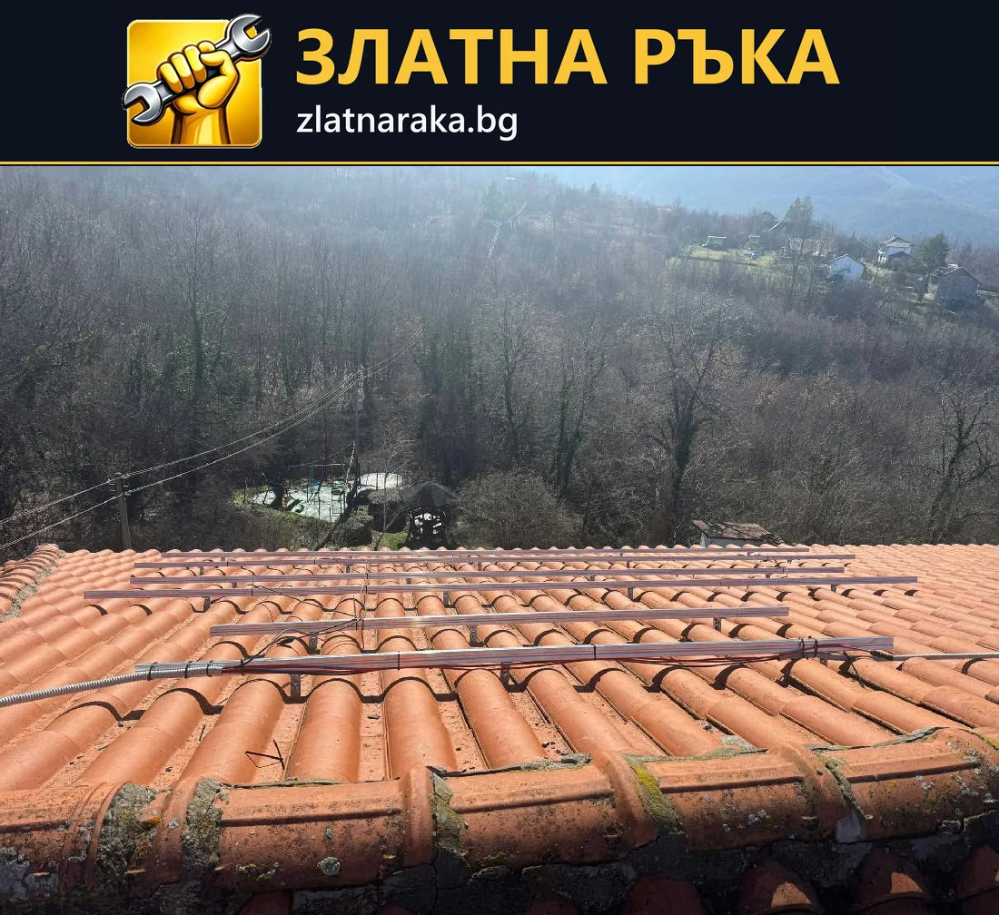 Успоредни метални шини са поставени над редове червени керемиди по скат към горист терен