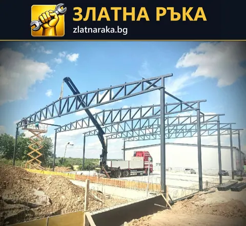 Открита метална конструкция с високи колони и покривни ферми, камион и подемна техника на строеж