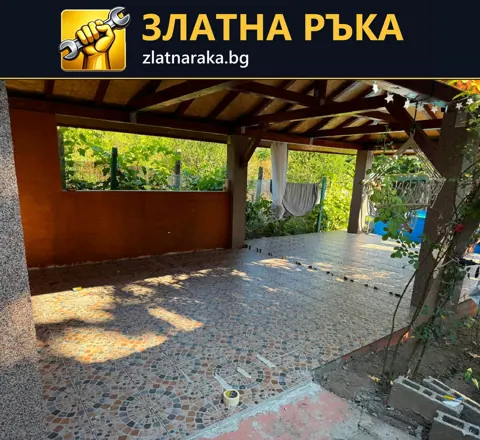 Покрита дворна зона с многоцветна мозаечна настилка около дърво