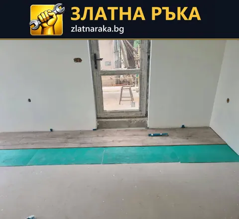 Няколко реда подови панели с дървесен рисунък върху зелена подложка край врата.