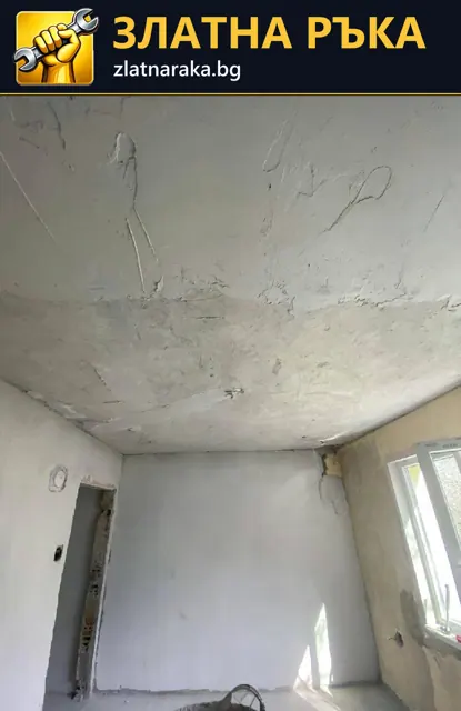 Повредено таванно покритие с пукнатини над светли стени и прозорци