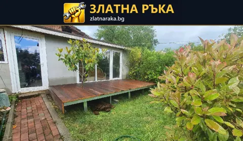 Ниска дървена площадка пред остъклен вход към двор
