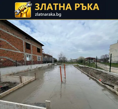 Голяма прясно оформена бетонна площ с две оранжеви тръби в средата и периферен кофраж