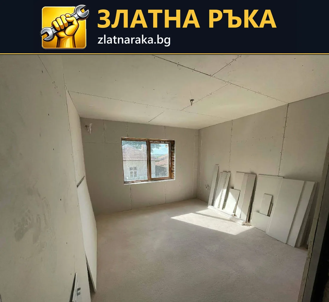 Помещение с нова суха облицовка по стените и тавана, видими фуги и един прозорец.