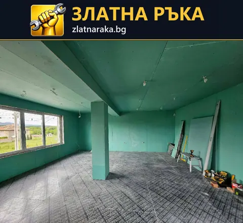 Стени и таван от зелени плоскости, централна колона и армираща мрежа върху пода