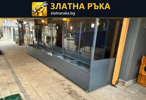 Продълговато остъклено ограждение със сив плътен долен панел пред заведение