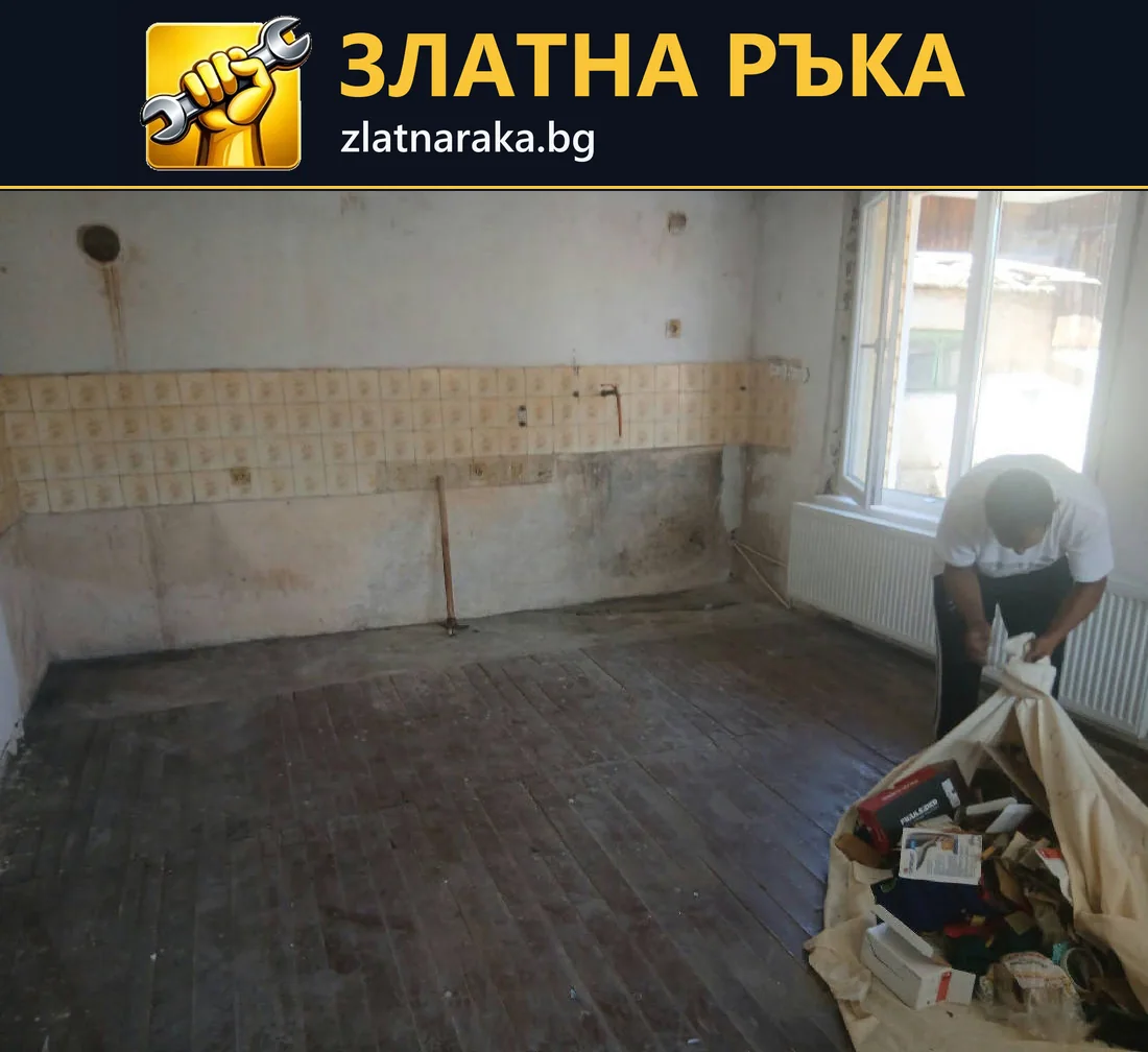 Празно помещение с тъмен под, останала ивица стенни плочки и събрани материали до прозореца