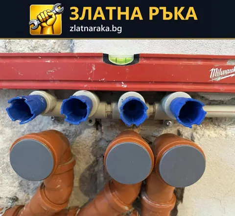 Четири защитени водни извода са подредени над три широки канализационни тръби в разкрита стена
